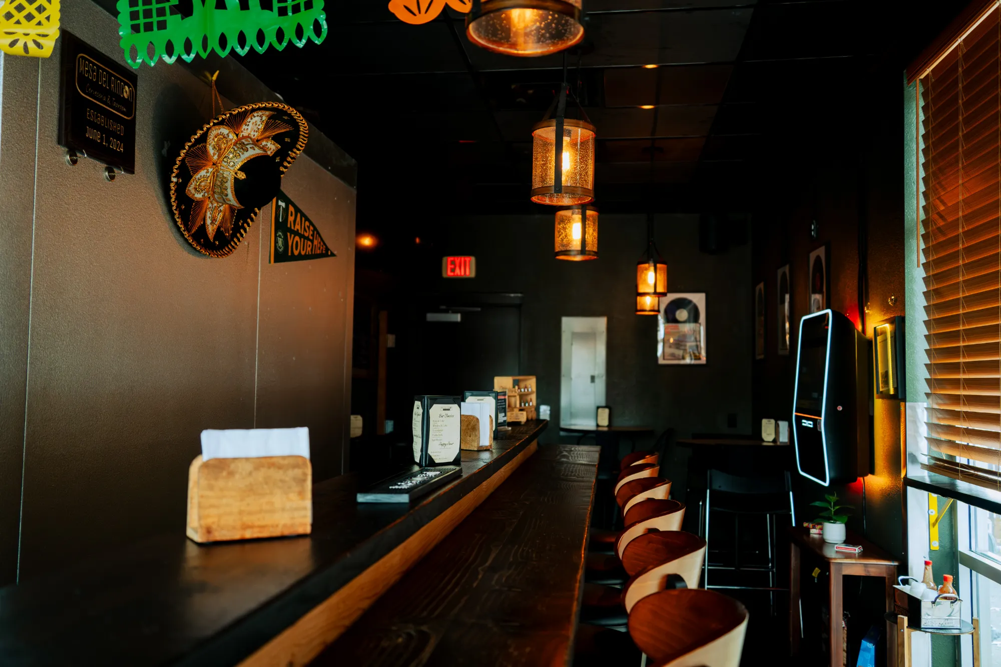 The long bar at Mesa del Rincon with stools and amber lighting