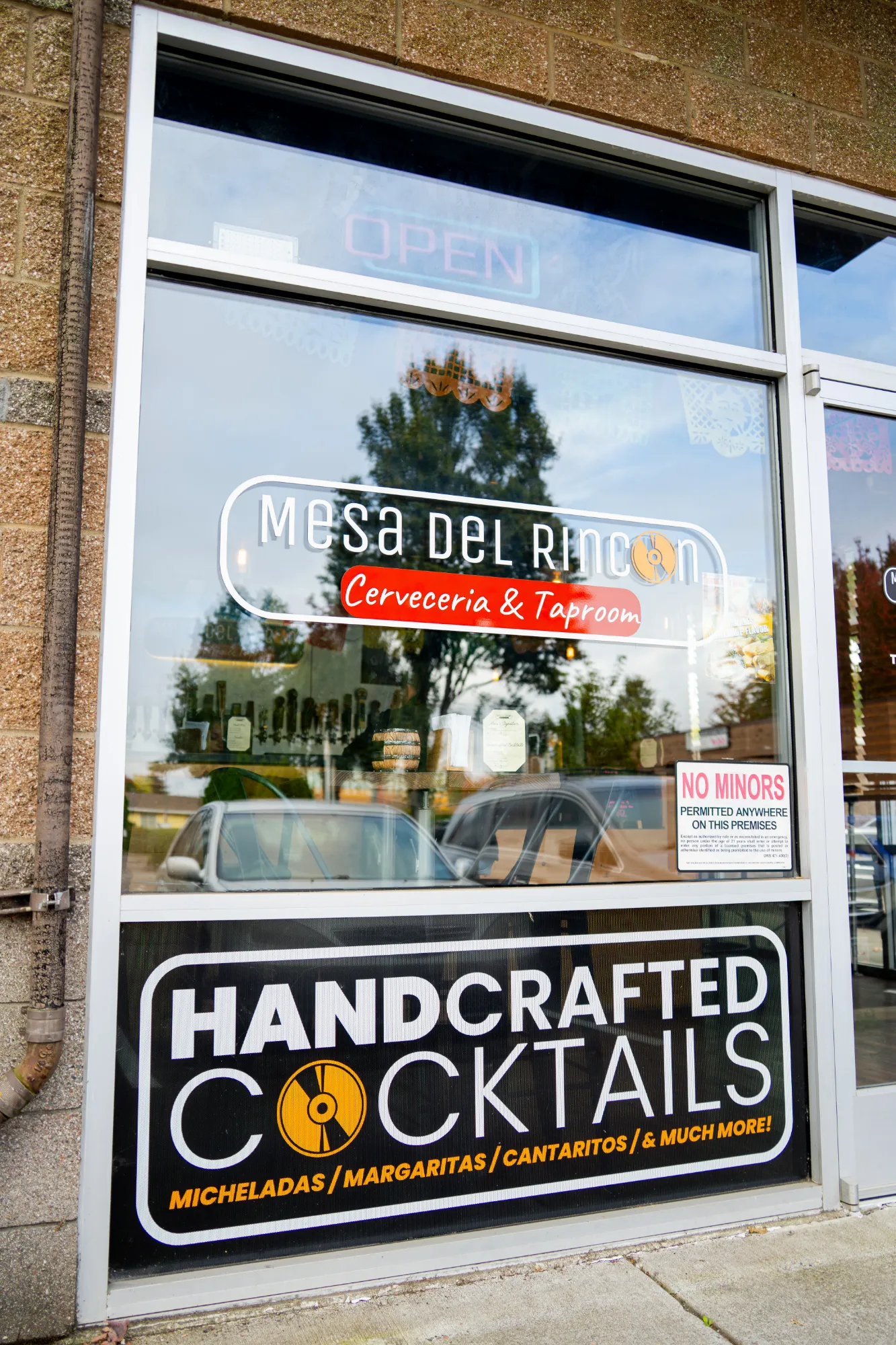 Mesa del Rincon storefront window with the logo and Handcrafted Cocktails sign