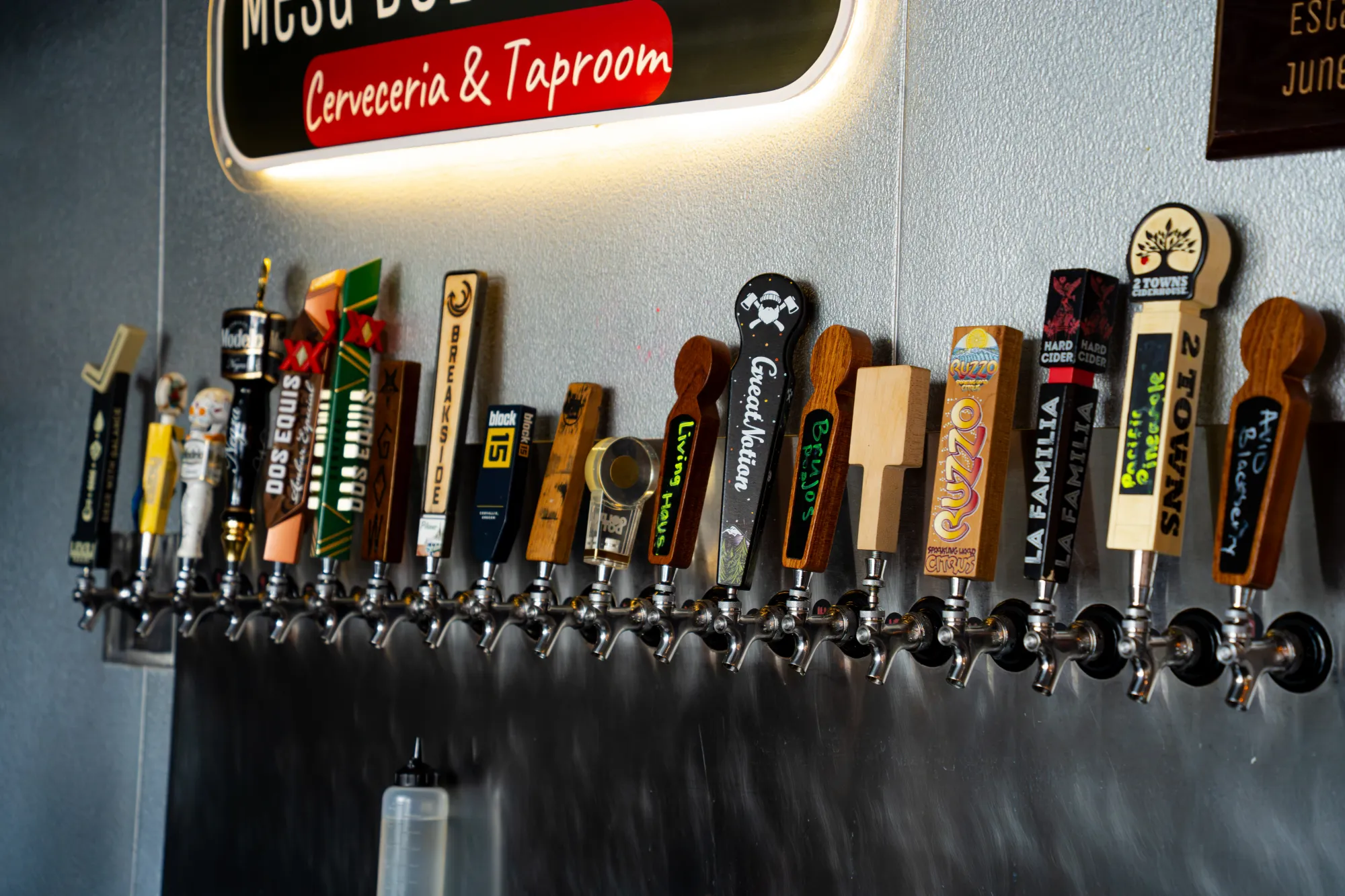 A long row of craft beer tap handles beneath the Mesa del Rincon sign